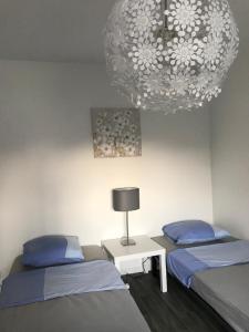 a room with two beds and a chandelier at Studio 5 Near Basel Airport in Saint-Louis