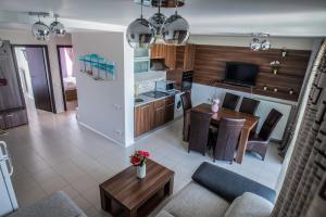 a kitchen and living room with a table and a couch at Neptun Blue Apartament in Neptun