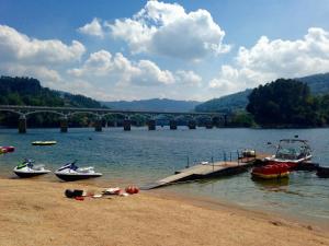 ジェレスにあるA nossa Casa Gerêsの川に架かる橋と岸に停泊している船