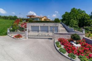 a house with a gate and flowers in the driveway at Villa GioAn - max 18, Private Playground and Sea View in Materada