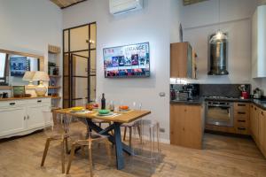 una cucina con tavolo e sedie in una stanza di One & Only Buonarroti Suite a Roma
