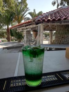 a green drink in a glass sitting on a table at Marti Resort in Skala Sotiros