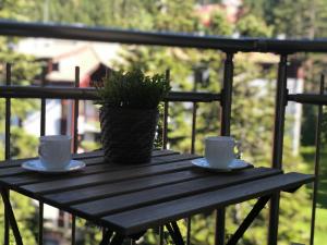 a wooden table with two cups and a potted plant on it at Deluxe 707 in Borovets