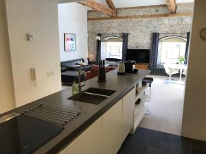 uma cozinha com um balcão preto e uma sala de estar em Royal William Yard Apartment em Plymouth