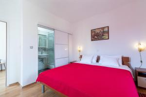 尼亚卢卡Marica Guesthouse的红色的床铺,位于白色的房间里,配有红色的毯子