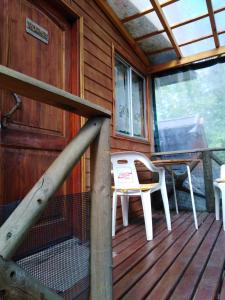 a porch of a cabin with a bench and a table at Cabañas Spa Bungalows Huarranchi in Pucón