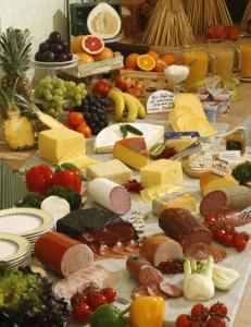 a table full of different types of cheese and fruit at Pension am Großen Garten in Dresden