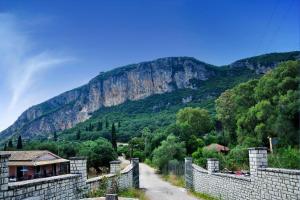 a view of a mountain from a stone wall at Anastasios Paleokastritsa apartment in Doukádes