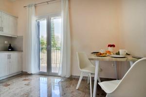 a kitchen with a table and chairs and a window at Anastasios Paleokastritsa apartment in Doukádes +18 photos