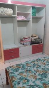 a bedroom with red and white shelves and a bed at casa de temporada coroados in Guaratuba