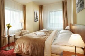 una camera d'albergo con un letto grande e una sedia di Clarion Congress Hotel České Budějovice a České Budějovice