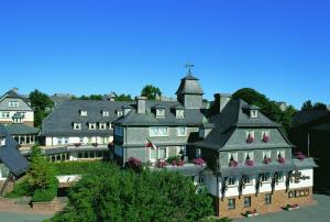 a large building with flowers in the windows at Fletcher Berghotel Astenkrone-Winterberg in Winterberg