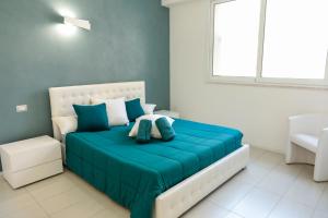 a bedroom with a bed with blue sheets and a window at The Smerald in Alghero