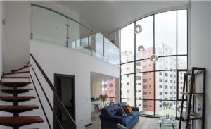 a living room with a blue couch and large windows at ESPECTACULAR LOFT in Quito