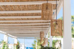 two chandeliers hanging from awnings on a porch at Boutique Hotel Oriola in Cala de Sant Vicenc