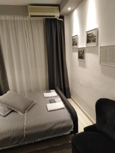 ein Schlafzimmer mit einem Bett und einem Stuhl darin in der Unterkunft Mini Central Studio in Thessaloniki