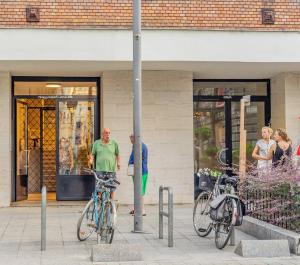 un grupo de personas de pie fuera de una tienda con bicicletas en Gabi's Central Broadway Nest @ Nagymező str, en Budapest