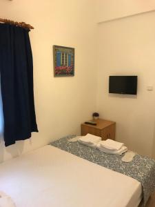 een hotelkamer met een bed en een televisie bij Tay Pansiyon in Bodrum City