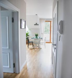 a kitchen and dining room with a table and chairs at Apartament Miętowy Zakątek Jastrzębia Góra in Jastrzębia Góra