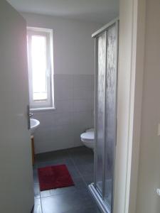 La salle de bains est pourvue de toilettes, d'un lavabo et d'une fenêtre. dans l'établissement Altstadt Ferienwohnung Stralsund mit Parkplatz, à Stralsund