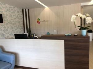 an office with a reception desk and flowers on the wall at Hotel Florida in A Lanzada