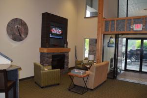 a living room with a fireplace and a sign on the wall at Days Inn by Wyndham Cadillac in Cadillac