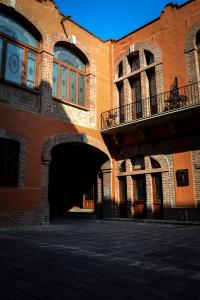 a large brick building with an archway in front of it at Casa San Jacinto in Mexico City