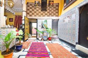 un pasillo con plantas y una alfombra en el suelo en Dar Berrada - Ziat, en Fez