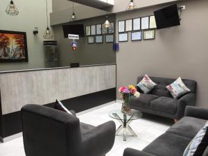 una sala de espera con sofás y un mostrador en Hostal Parisuite en Lima