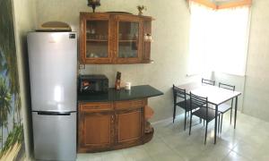 a kitchen with a refrigerator and a table with chairs at Green house Ureki in Ureki