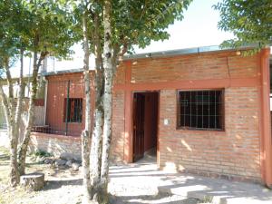 a red brick building with trees in front of it at Hospedaje Sol de Reyes Jujuy in Reyes