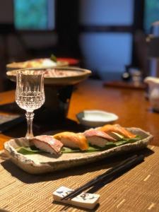 une assiette de nourriture sur une table avec un verre dans l'établissement Minshuku Takizawa, à Takayama