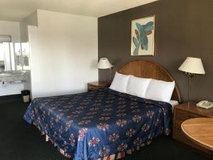 Economy Inn Barstow في بارستو: غرفه فندقيه بسرير وهاتف