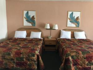 Tempat tidur dalam kamar di Economy Inn Barstow