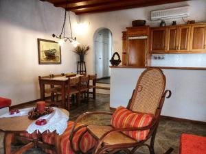 a living room with a table and chairs and a kitchen at Laggades Relaxing House in Tinos