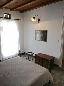 una camera con letto, tavolo e finestra di Laggades Relaxing House a Città di Tinos