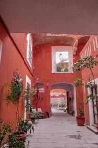 a red building with a courtyard with potted plants at Hotel el Descanso in Puebla