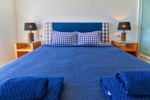 a blue bed with two night stands and two lamps at Penthouse Reserva del Higueron in Benalmádena +17 photos