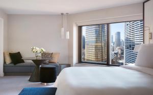 a hotel room with a bed and a large window at Four Seasons Hotel Sydney in Sydney