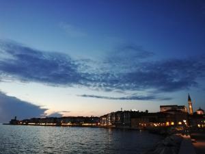 una vista di una città di notte con un corpo d'acqua di Camera al Porto Antico a Piran