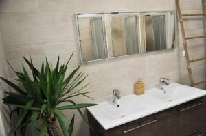 a bathroom with two sinks and a potted plant at Green Element Guesthouse in Costa da Caparica