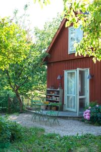 a red house with a bench in front of it at Harrys Hardware Home in Brösarp