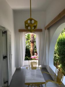 a dining room with a table and chairs and a window at Manolis' House in Skiathos Town