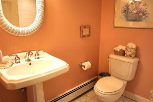 a bathroom with a sink and a toilet and a mirror at The Whalewalk Inn & Spa in Eastham