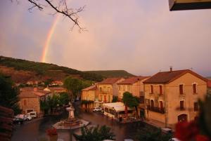 un arco iris en el cielo sobre una ciudad en Hotel Restaurant La Calade, en Octon