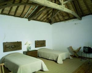 um quarto com duas camas e uma TV em Convento de São Francisco em Vila Franca do Campo