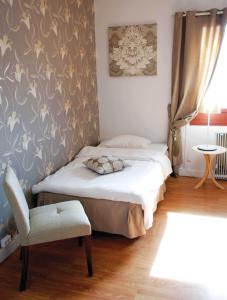 a small bedroom with a bed and a chair at Avesta Stadshotell in Avesta