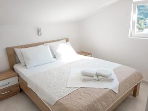 ein Schlafzimmer mit einem Bett mit zwei Handtüchern darauf in der Unterkunft Apartments Monako in Herceg-Novi