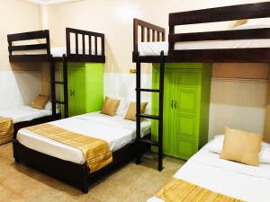2 łóżka piętrowe z zielonymi drzwiami w pokoju w obiekcie My Vigan Home Hotel w mieście Vigan