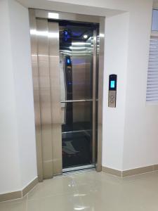 an elevator with a glass door in a building at HOTEL A1 EXPRESS in Florencia